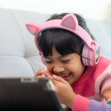 A Happy Asian little girl listening to music in the living-room