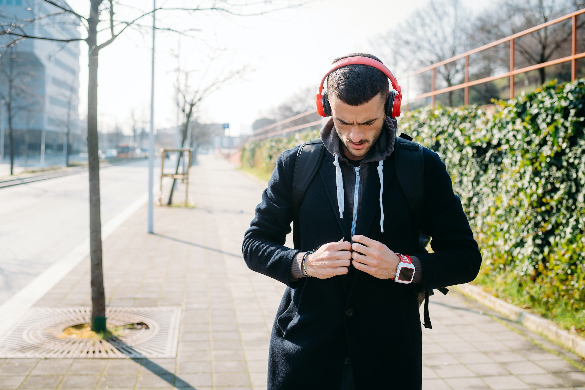 Young sportive man outdoor listening music with headphones concentrating